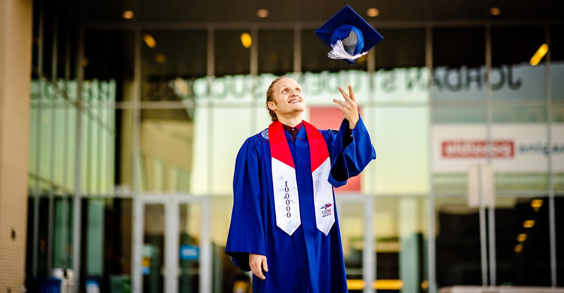 100,000th graduate Branden Ingersoll throwing cap in the air