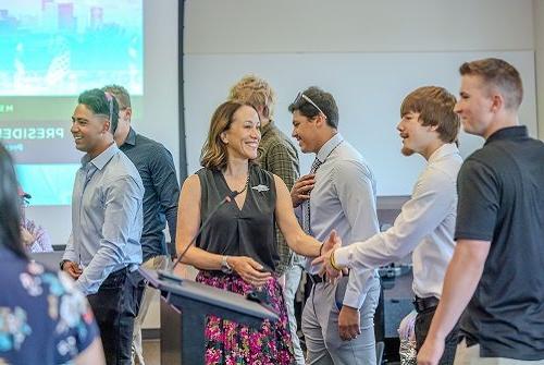 President Davidson shaking hands with baseball team members at President's Cabinet meeting August 2024